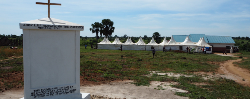 The massacre memorial in Abok, Northern Uganda. In the background: the tents for the public screening of the Ongwen trial (image: Jonas Bens).